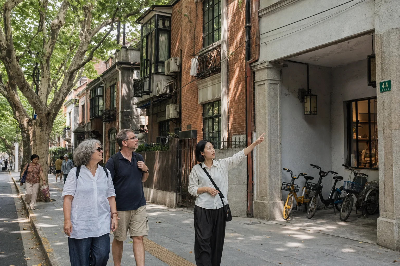 Travelers walking with a local guide past brick apartment buildings near Wukang and Anfu roads in Shanghai
